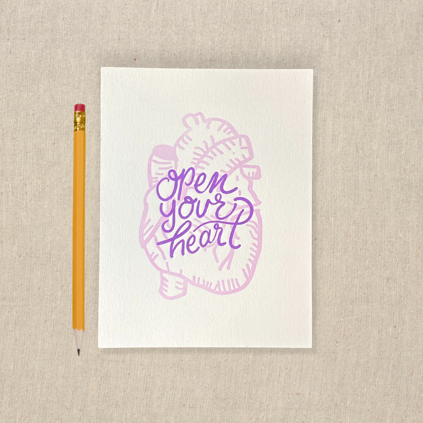 5 x 7 letterpress print with lilac anatomical heart drawing and purple lettering that says open your heart