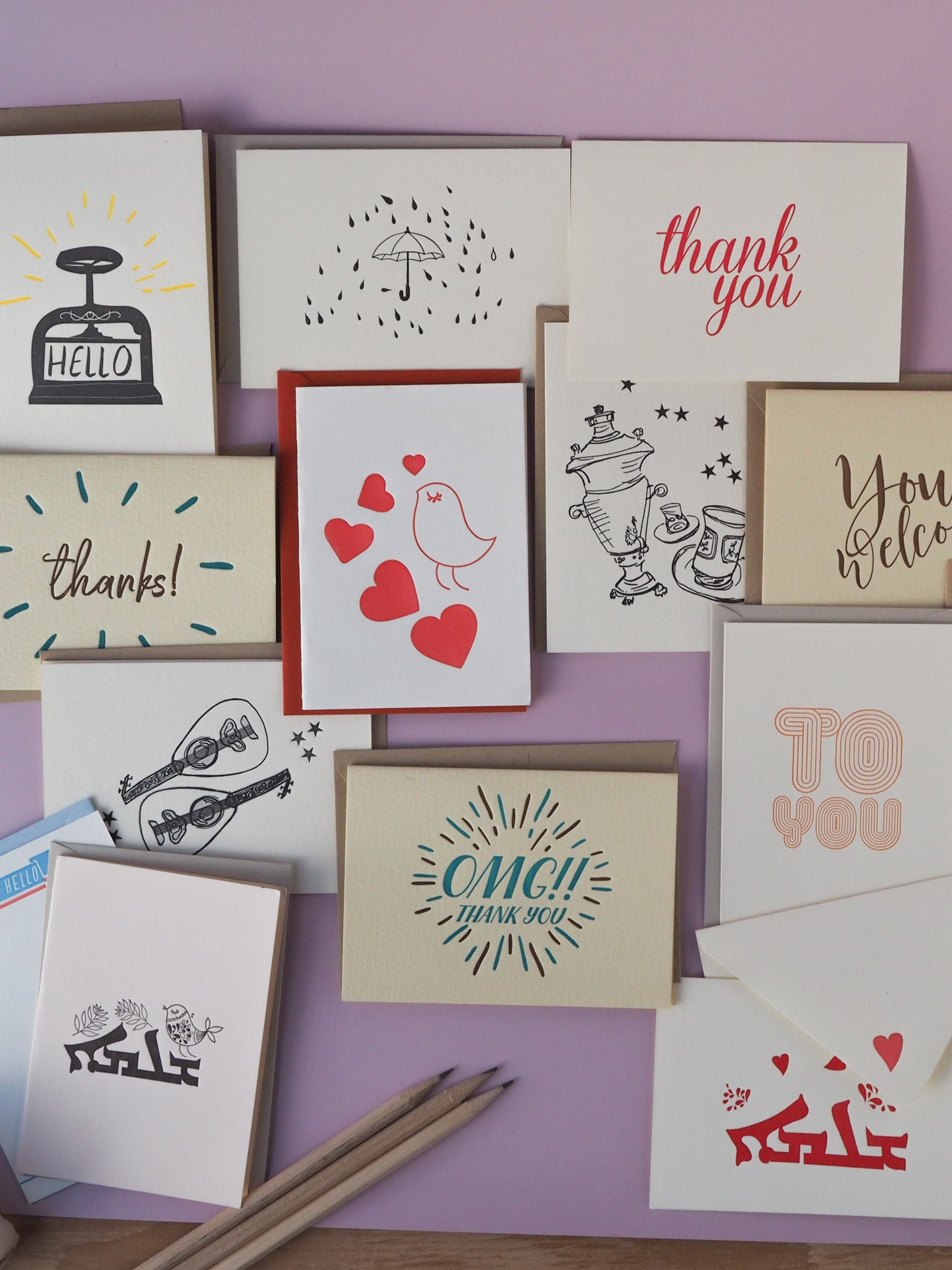grouping of various greeting cards on lilac background