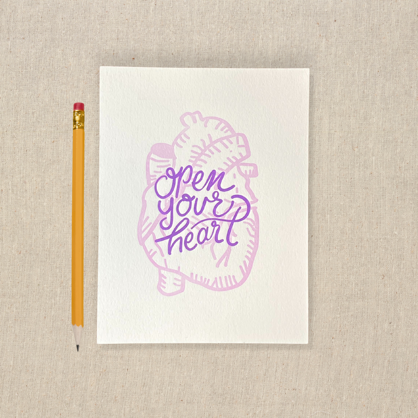 5 x 7 letterpress print with lilac anatomical heart drawing and purple lettering that says open your heart 